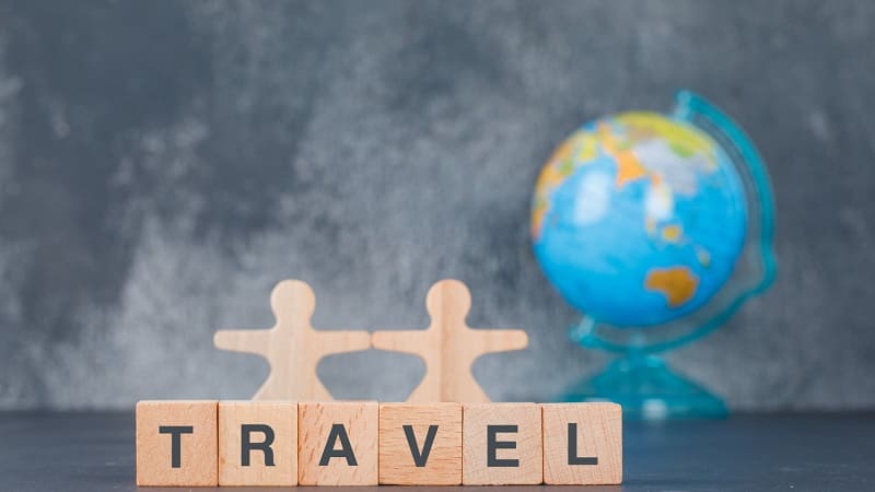 حروف TRAVEL با نماد کره زمین در پس‌زمینه