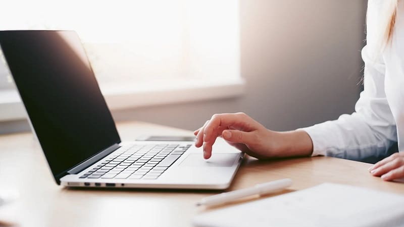 کارمند دفتر کاریابی نیک‌فرا در حال کار با لپ‌تاپ